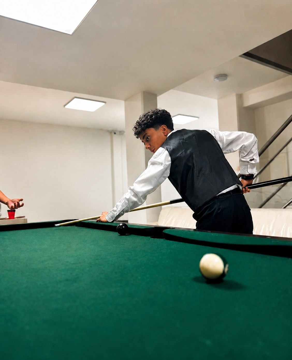 Un joven jugando billar en la zona recreativa de la planta baja